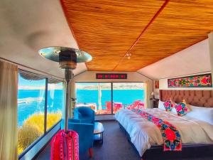 a bedroom with a bed and a large window at Uros Qhantany Lodge in Puno