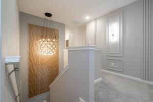 a hallway with a staircase with a light on the wall at Brand New Top Elegance Vacation Home at Paradiso Grande in Orlando