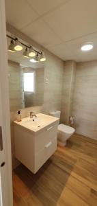 a bathroom with a sink and a toilet and a mirror at Balcón Playa Delicias in Águilas