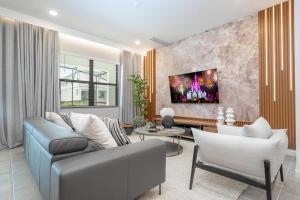 a living room with a couch and a tv on a wall at Brand New Top Elegance Vacation Home at Paradiso Grande in Orlando