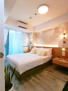 a bedroom with a large bed and a large window at Manila Urban Resort at Azure in Manila