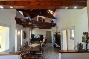 a living room with a table and chairs and a television at 10.000 m2 Casa de Campo Barrio de Chacra in San Andrés de Giles