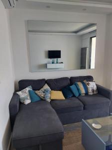 ein Wohnzimmer mit einem blauen Sofa und einem TV in der Unterkunft Chalet in Solemar,renovated,parking,Wifi elec247 in Jounieh