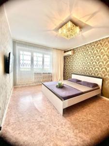 1 dormitorio con 1 cama grande en una habitación en Апартаменты на 12 мкр, en Aktobe