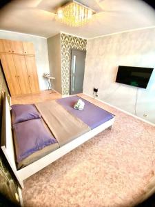 1 dormitorio con 1 cama y TV de pantalla plana en Апартаменты на 12 мкр, en Aktobe