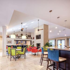 una sala da pranzo con sedie colorate e un bar di Hampton Inn & Suites Wilmington/Wrightsville Beach a Wilmington