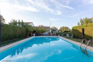 a swimming pool with blue water in a yard at Casa Rural Tazgona in Antequera