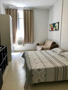 a bedroom with a bed and a couch and a window at Apartamento Copacabana Posto5 in Rio de Janeiro