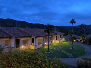 a view of a villa at night with palm trees at Residence Alithai in Portoferraio