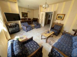 a living room with blue couches and a tv at New Jdeideh, Including Generator, Furnished Apartment, Parking, great location in Nahr al Mawt