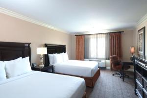 une chambre d'hôtel avec deux lits et une chaise dans l'établissement Best Western Ontario Mills Mall, à Ontario