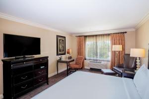 ein Hotelzimmer mit einem Bett und einem Flachbild-TV in der Unterkunft Best Western Ontario Mills Mall in Ontario