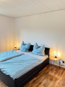 Un dormitorio con una cama con almohadas azules. en 4-h3rOeS Legoland Günzburg Wohnung 1, en Leipheim