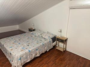 1 dormitorio con 1 cama y 1 mesa con mesita de noche en duplex HIBISCUS, en Sainte-Clotilde