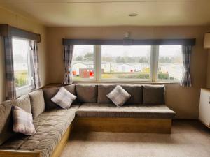 ein Sofa im Wohnzimmer mit einem großen Fenster in der Unterkunft Kent Coast 3 bedroom holiday home in Rochester