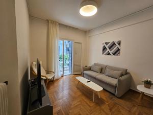 uma sala de estar com um sofá e uma televisão em Athena Elegant Apartment em Atenas