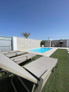 un patio con tumbonas y una piscina en Casa Roche en Cádiz