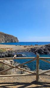 une clôture en bois sur une plage près de l'océan dans l'établissement Apartman Los Cristianos-Cristimar, à Los Cristianos