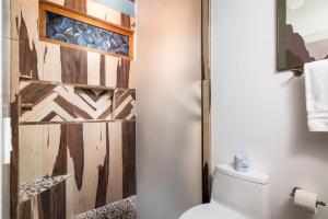 een badkamer met een toilet en een houten muur bij The Motor Lodge in Prescott