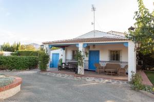 Cette petite maison dispose de portes bleues et d'une terrasse. dans l'établissement Casa Rural Tazgona, à Antequera