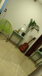a guitar and a table and a chair in a room at Eucalipto in Mar del Plata