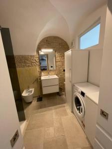 a bathroom with a refrigerator and a sink and a washing machine at Greta’s suite & private spa in Perinaldo