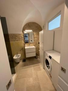 a bathroom with a refrigerator and a sink and a washing machine at Greta’s suite & private spa in Perinaldo +34 photos
