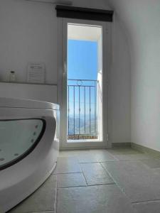 a bathroom with a tub and a view of the ocean at Greta’s suite & private spa in Perinaldo