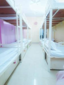 a room with white bunk beds in a hospital at BASERA DORMITORY in Lucknow