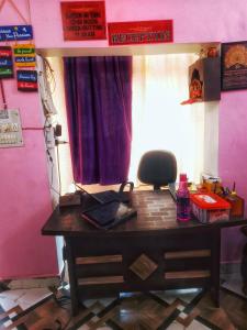 a desk in a room with a pink wall at BASERA DORMITORY in Lucknow
