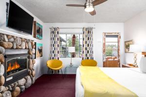 Habitación de hotel con cama y chimenea en The Motor Lodge en Prescott