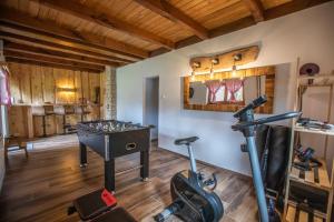 a room with a gym with a table and a treadmill at Vacation house Kula in Jasenak