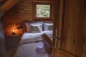 ein Schlafzimmer mit einem Bett in einer Holzhütte in der Unterkunft Vacation house Kula in Jasenak