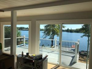 a screened in porch with a view of the water at Canobie Lake 3bedroom waterfront in Windham