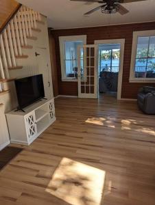 a living room with a television and a staircase at Canobie Lake 3bedroom waterfront in Windham