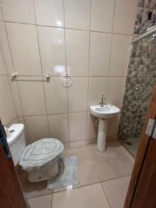 uma casa de banho com um WC e um lavatório em A CASA DE IRENE IV em Aparecida
