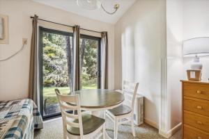 a dining room with a table and chairs and a window at Cedarbrook Standard Hotel Room 105 in Killington