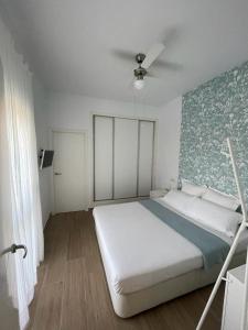 een slaapkamer met een bed en een plafondventilator bij Atico en Puerto Marina in Benalmádena