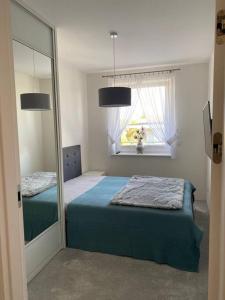 a bedroom with a mirror and a bed and a window at Apartament Holiday Amber in Rewal