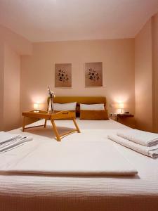 a bedroom with a large white bed with two lamps at Feel at home - Kalamata - Near the center in Kalamata