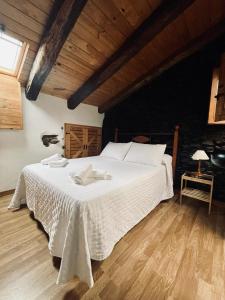 ein großes weißes Bett in einem Zimmer mit Holzdecke in der Unterkunft La Casa del Castaño in Aracena + 16 Fotos