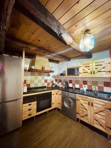 eine Küche mit einem Kühlschrank aus Edelstahl und einem Geschirrspüler in der Unterkunft La Casa del Castaño in Aracena