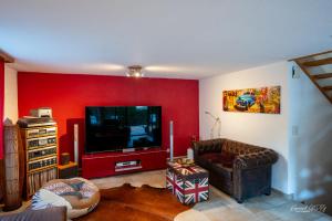 sala de estar con sofá y TV de pantalla plana en Zimmer mit eigenem Badezimmer en Näfels