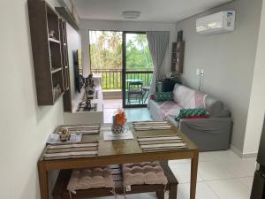 Flat Confort Pé na Areia في إيبوجوكا: غرفة معيشة مع طاولة وأريكة