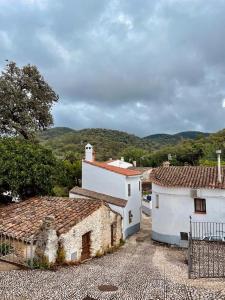 eine Gruppe von Gebäuden mit Bergen im Hintergrund in der Unterkunft La Casa del Castaño in Aracena