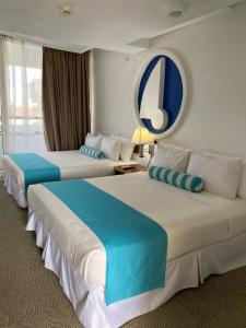 a hotel room with two beds with blue and white at Aquarius Hotel Boutique in Pampatar