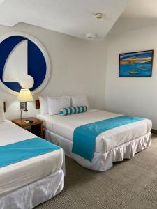 a hotel room with two beds and a window at Aquarius Hotel Boutique in Pampatar