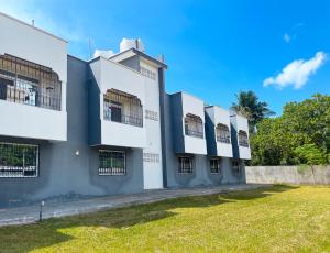 un gran edificio blanco con un patio de césped en KITRA Cozy Homes, en Kilifi