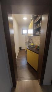 eine kleine Küche mit gelben Schränken und einem Fliesenboden in der Unterkunft AS Apartman Visoko in Visoko