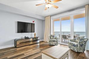 a living room with a flat screen tv and a large window at Calypso 3-2210 - Love Nest in Panama City Beach